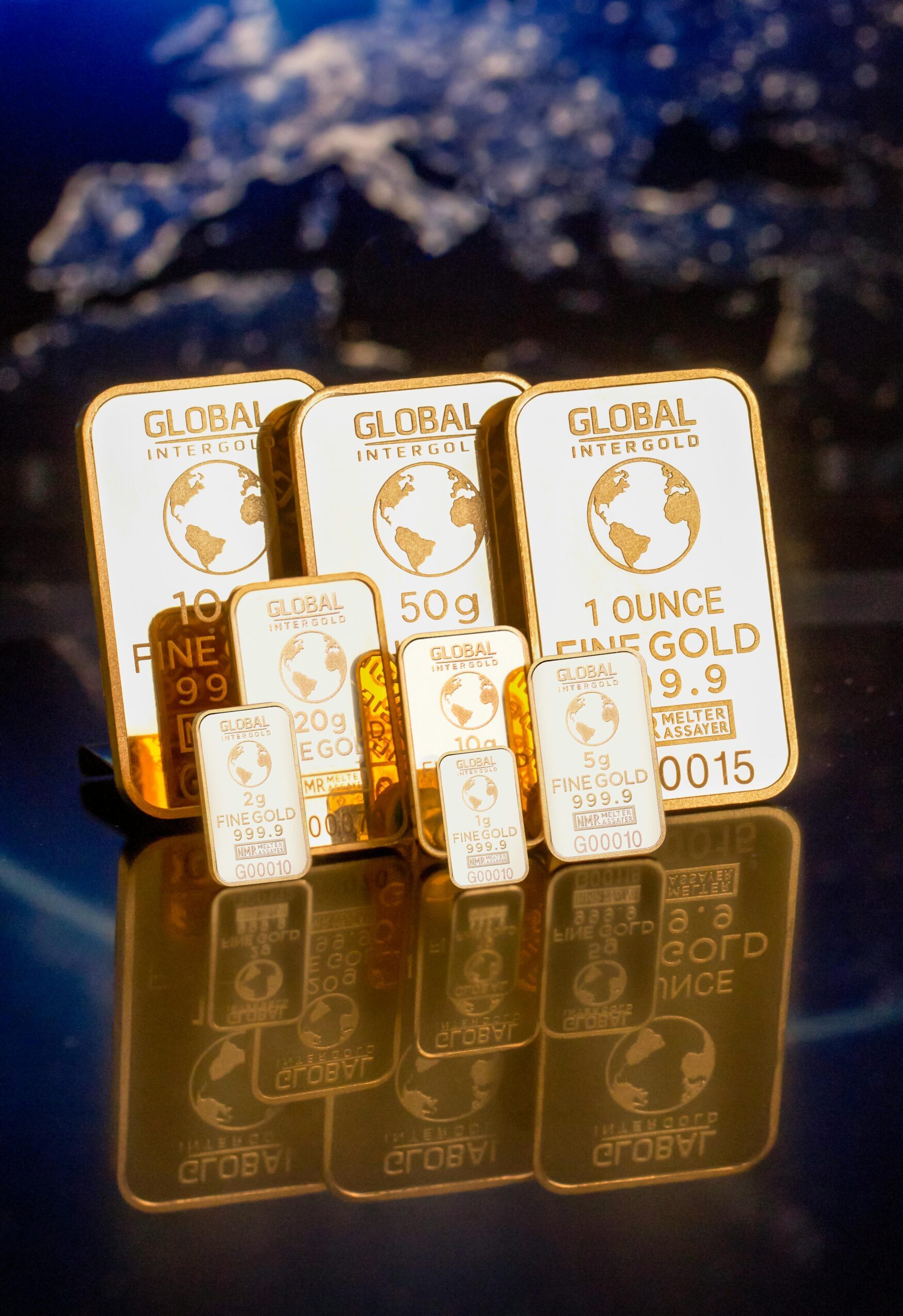 Collection of gold bars featuring a global map and weight inscriptions.